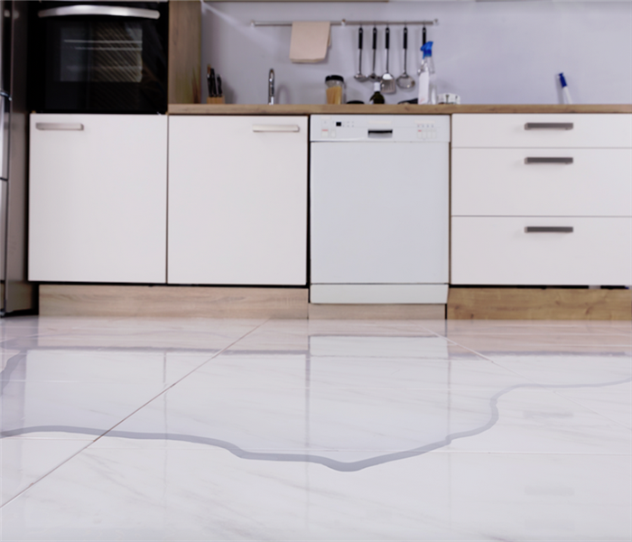 a flooded kitchen with water covering the tile floor